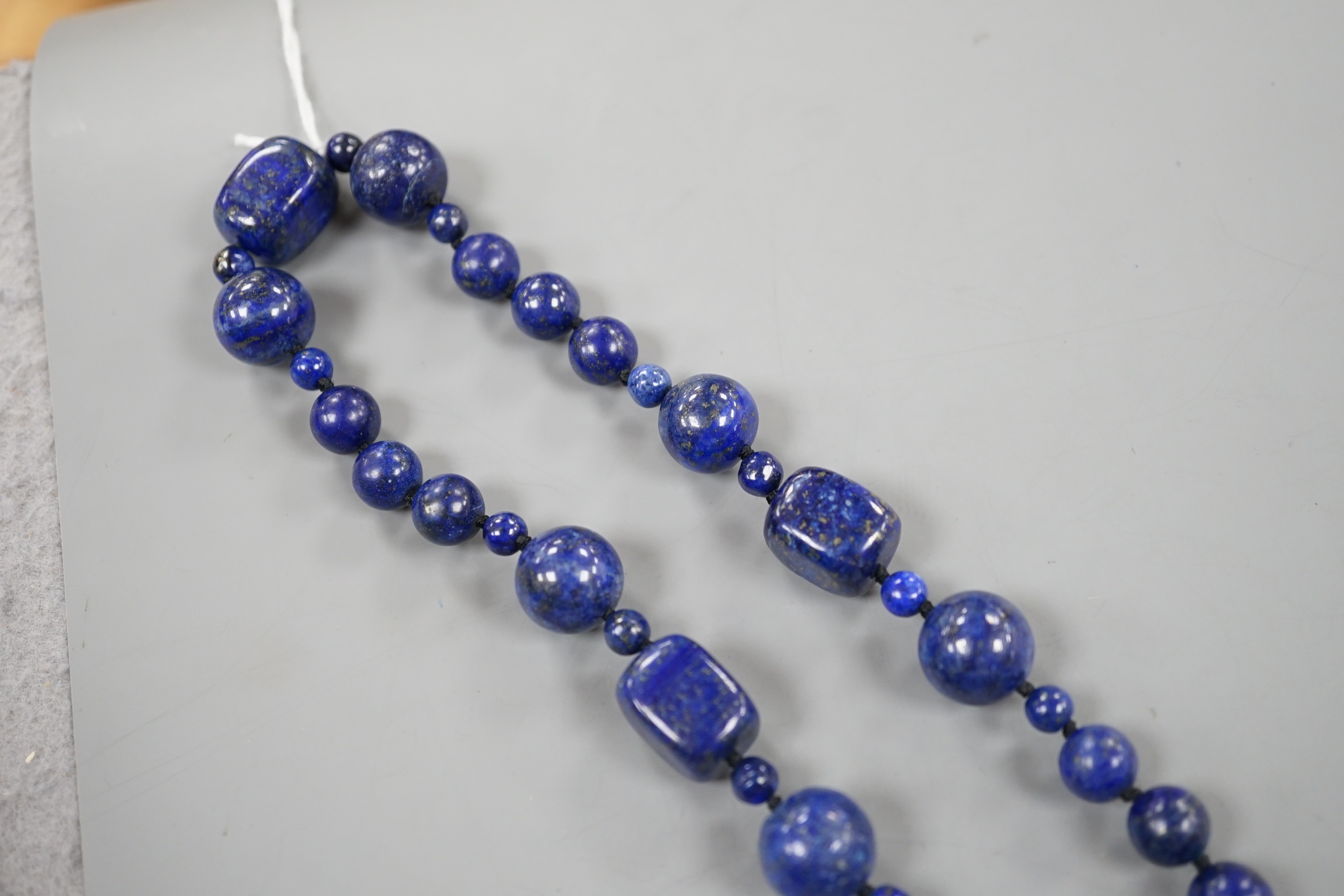 A single strand lapis lazuli round and barrel bead necklace, 72cm.